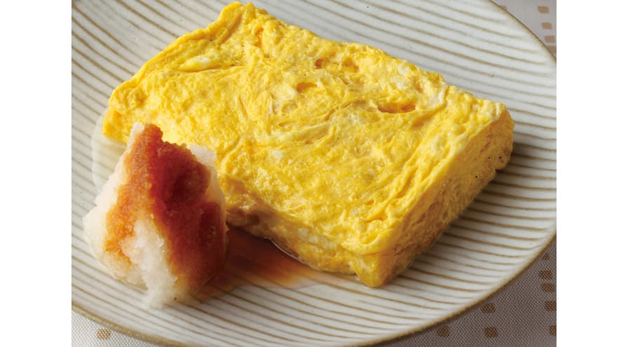 特製だし巻きたまご。厚焼き卵を切り分け、竹の葉に載せて提供