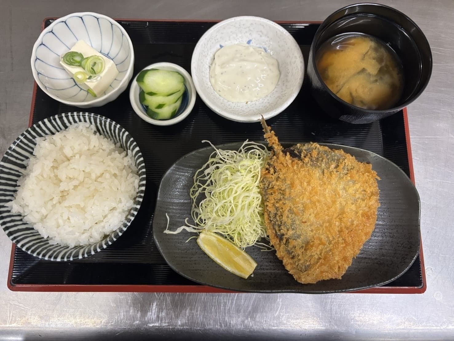 アジフライ定食。大きなアジフライとタルタルソース・ご飯・味噌汁・漬物・冷奴付きで850円