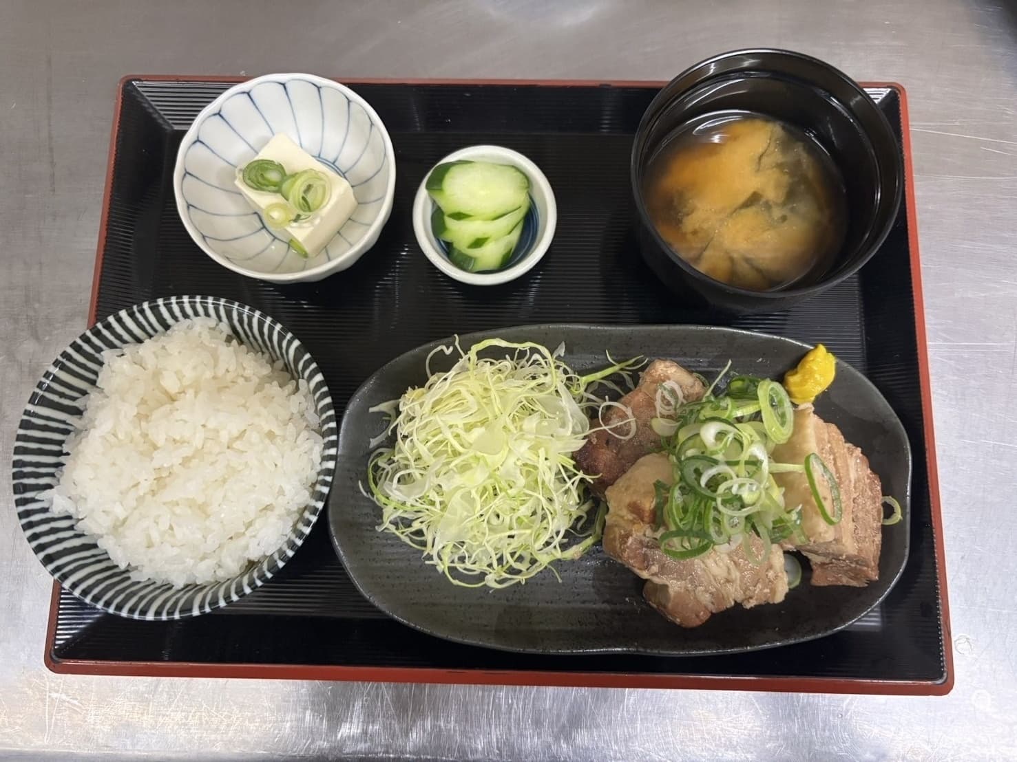 豚角煮定食。柔らかく煮込んだ角煮にネギ・ご飯・味噌汁・漬物・冷奴付き